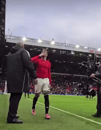 A Man In A Red Shirt With The Number 10 On His Shorts Stands On A Soccer Field GIF