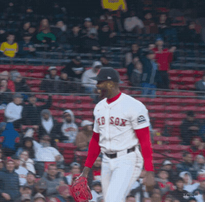 A Man In A Red Sox Jersey Stands In Front Of A Crowd Of People GIF
