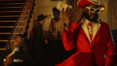 A Man In A Red Suit And Cowboy Hat Stands In Front Of A Sign That Says Employment Only GIF