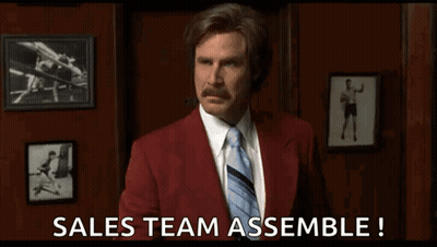 A Man In A Red Suit And Tie Is Saying Sales Team Assemble . GIF