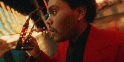 A Man In A Red Suit Holds A Pair Of Glasses GIF