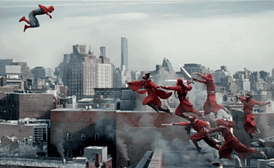 A Man In A Red Suit Is Flying Through The Air In Front Of A City GIF