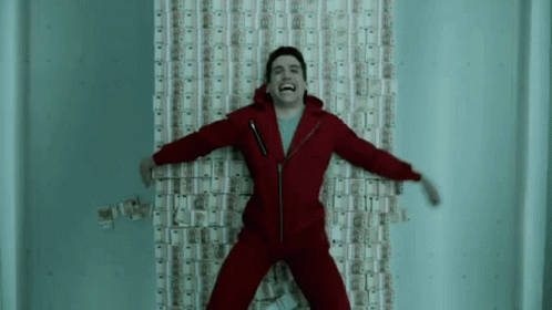A Man In A Red Suit Is Laying On A Wall Covered In Money And Laughing . GIF