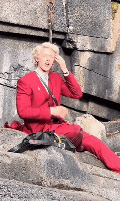 A Man In A Red Suit Is Sitting On The Ground GIF