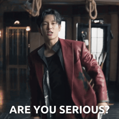 A Man In A Red Suit Is Standing In Front Of Ropes And The Words Are You Serious GIF