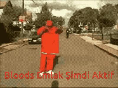 A Man In A Red Suit Is Walking Down A Street With The Words Bloods Emlak Şimdi Aktif Written Below Him GIF