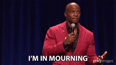 A Man In A Red Suit Stands In Front Of A Microphone And Says I 'M In Mourning GIF