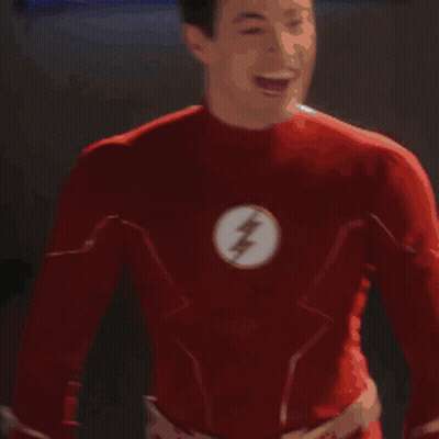 A Man In A Red Superhero Costume Is Standing In Front Of A Display Of A Man In A Red Suit GIF