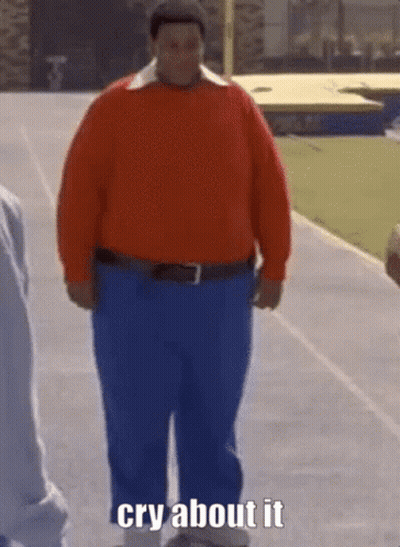 A Man In A Red Sweater And Blue Pants Is Walking Down A Track And Says Cry About It . GIF