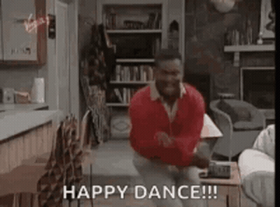 A Man In A Red Sweater Is Dancing In A Living Room With The Words `` Happy Dance '' . GIF