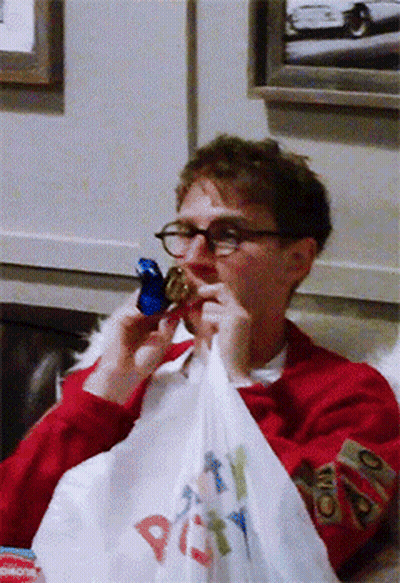 A Man In A Red Sweater Is Holding A Bag That Says Party GIF