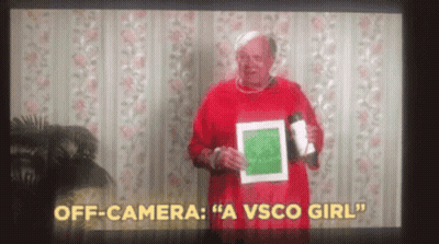 A Man In A Red Sweater Is Holding A Cup And A Piece Of Paper In Front Of A Camera . GIF