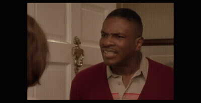 A Man In A Red Sweater Is Making A Funny Face GIF