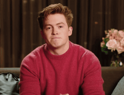 A Man In A Red Sweater Is Making A Funny Face GIF