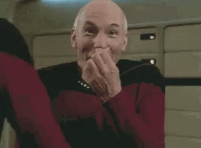 A Man In A Red Sweater Is Making A Funny Face While Standing In A Room . GIF