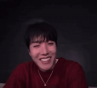 A Man In A Red Sweater Is Making A Funny Face With His Eyes Closed . GIF