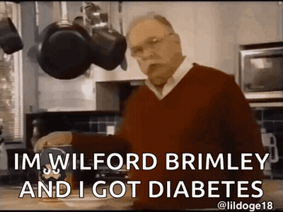 A Man In A Red Sweater Is Standing In A Kitchen And Says " Im Wilford Brimley And I Got Diabetes " . GIF