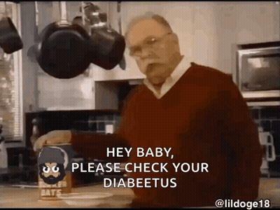 A Man In A Red Sweater Is Standing In A Kitchen With A Box Of Baker 'S Oats On The Counter GIF