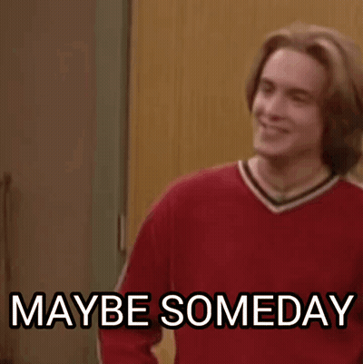 A Man In A Red Sweater Is Standing In Front Of A Door And Smiling . GIF