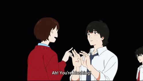 A Man In A Red Sweater Is Talking To Another Man In A White Shirt Who Is Blushing GIF