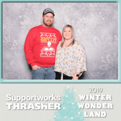 A Man In A Red Sweater Stands Next To A Woman In A White Floral Shirt GIF