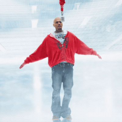 A Man In A Red Sweatshirt Is Holding A Microphone GIF