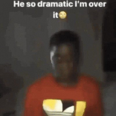 A Man In A Red T-Shirt Is Standing In Front Of A Television . GIF