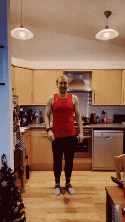 A Man In A Red Tank Top And Black Pants Is Standing In A Kitchen GIF