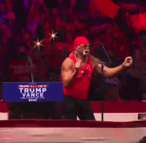 A Man In A Red Tank Top Is Standing In Front Of A Trump Vance Sign GIF