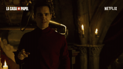 A Man In A Red Turtleneck Stands In Front Of A Netflix Logo GIF