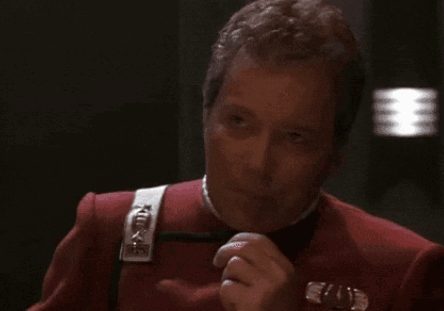 A Man In A Red Uniform Is Covering His Mouth GIF