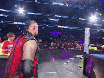 A Man In A Red Vest Stands In Front Of A Crowd At A Smack Wrestling Event GIF