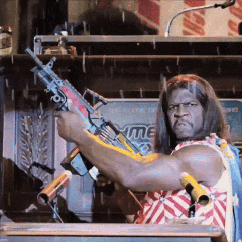 A Man In A Red White And Blue Outfit Is Holding A Gun GIF