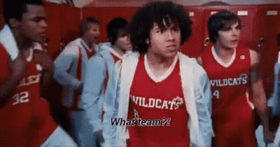 A Man In A Red Wildcats Jersey Is Standing In A Locker Room GIF