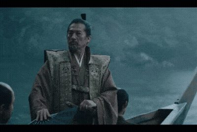 a man in a robe is standing in a boat