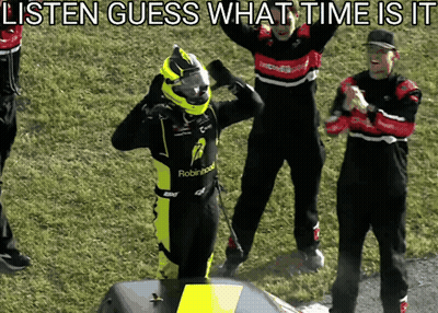 A Man In A Robinhood Racing Suit Stands On A Podium GIF