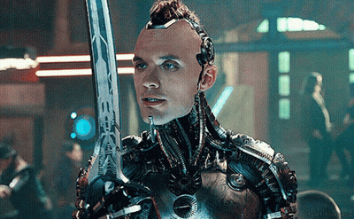 A Man In A Robotic Suit Is Holding A Sword In His Right Hand GIF