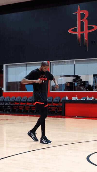 A Man In A Rockets T-Shirt Is Walking On A Basketball Court GIF
