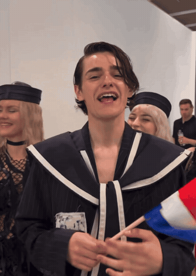 A Man In A Sailor Costume Is Smiling And Holding A French Flag GIF