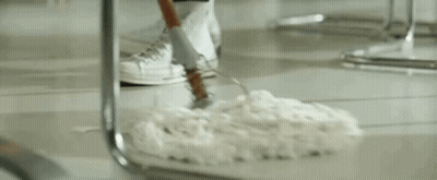 A Man In A Sailor Outfit Is Standing In Front Of A Counter In A Restaurant Holding A Mop . GIF