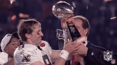 A Man In A Saints Jersey Is Holding A Trophy With The Nfl Logo On It GIF
