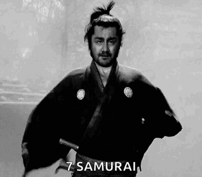 A Man In A Samurai Costume Is Holding A Sword In His Hand . GIF