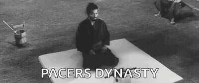 A Man In A Samurai Costume Is Kneeling On A Mat . GIF