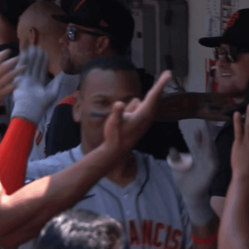 A Man In A San Francisco Jersey Is Being High Fived By His Teammates GIF