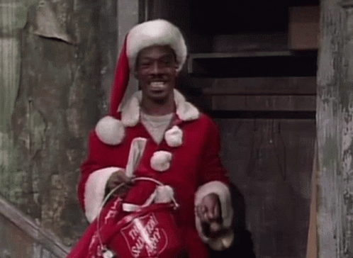 A Man In A Santa Claus Costume Is Holding A Bucket And A Newspaper . GIF