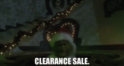 A Man In A Santa Hat Is Standing In Front Of A Christmas Tree With Lights . GIF
