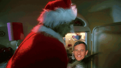 A Man In A Santa Hat Stands In Front Of A Refrigerator GIF