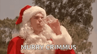A Man In A Santa Suit Is Drinking From A Glass . GIF