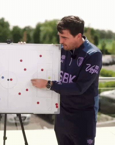 A Man In A Sbk Shirt Is Holding A Whiteboard GIF