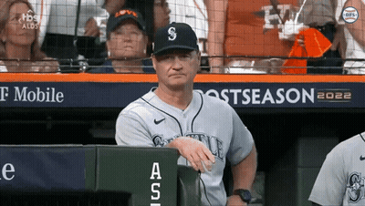 A Man In A Seattle Baseball Uniform Sits In The Dugout During A Game GIF